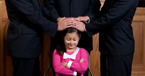 girl receiving priesthood blessing