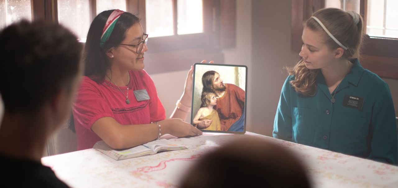 Missionaries showing a painting of Jesus Christ on a tablet