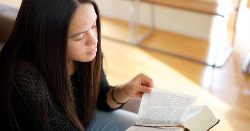 Eine junge Dame liest in den heiligen Schriften und denkt nach