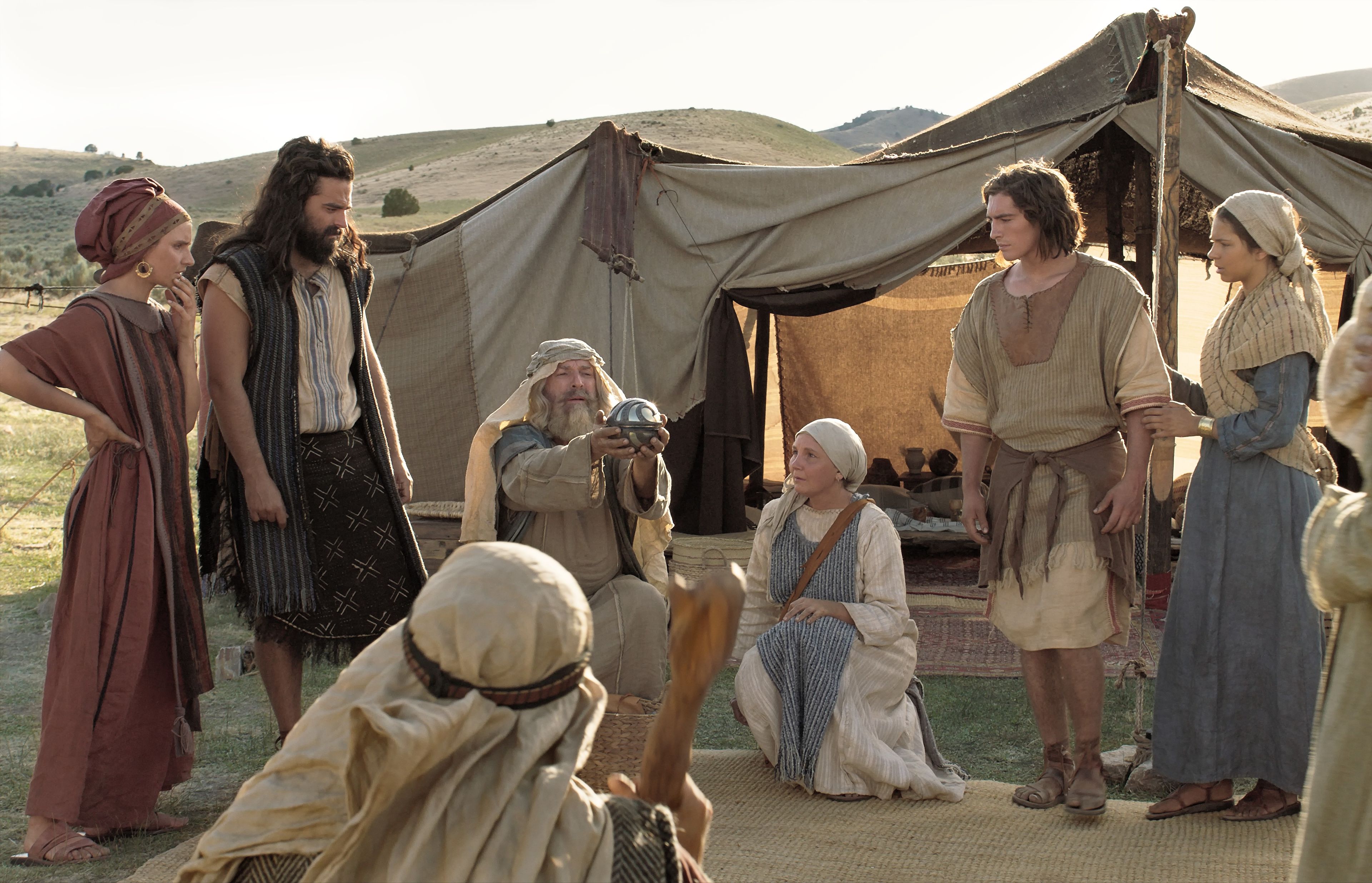 Lehi shows his family the Liahona in the wilderness.