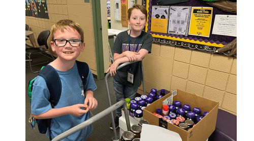 Two boys with donations collected at food drive