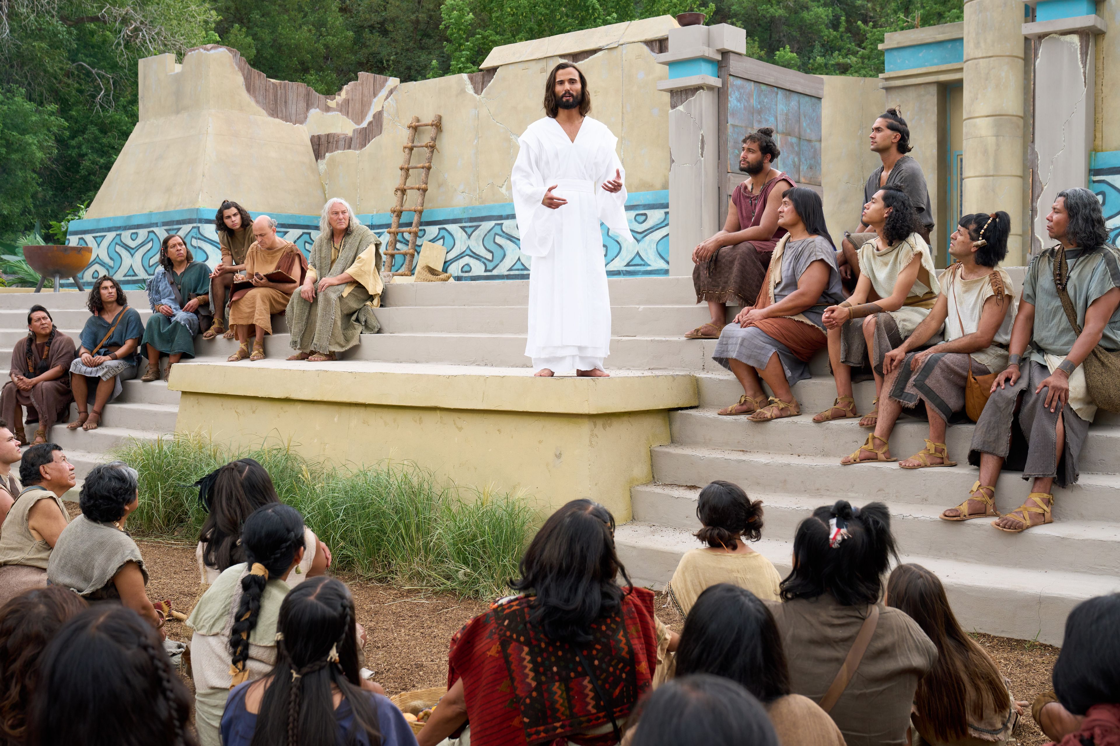 The resurrected Savior, Jesus Christ, teaches the people his Gospel. The Twelve Disciples sit on either side of him.