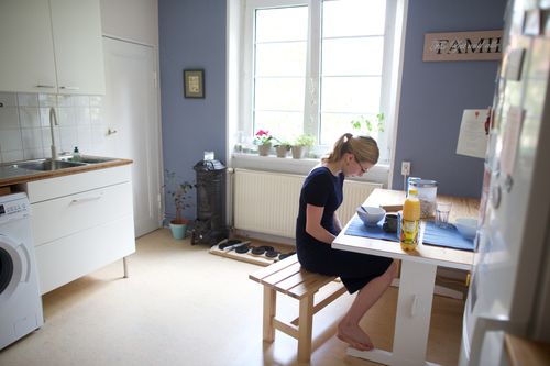 Eine junge Frau betet am Küchentisch