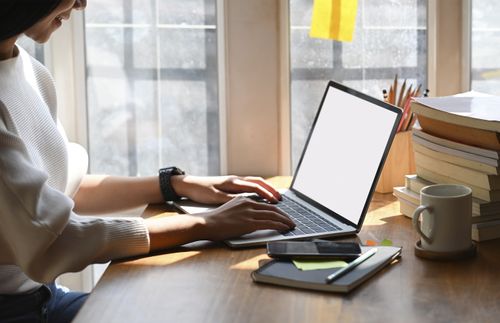 woman sitting and typing on a laptop