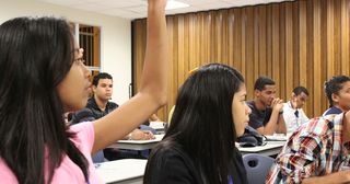 Una alumna levanta la mano para hacer una pregunta