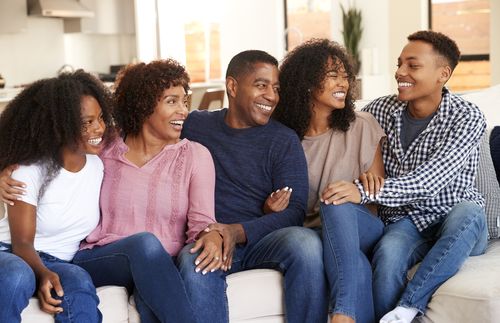 una familia sentada en un sofá y sonriendo