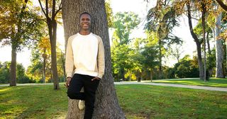 young man leaning against tree