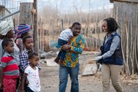 Uma mulher encontra uma família realizando um serviço para eles