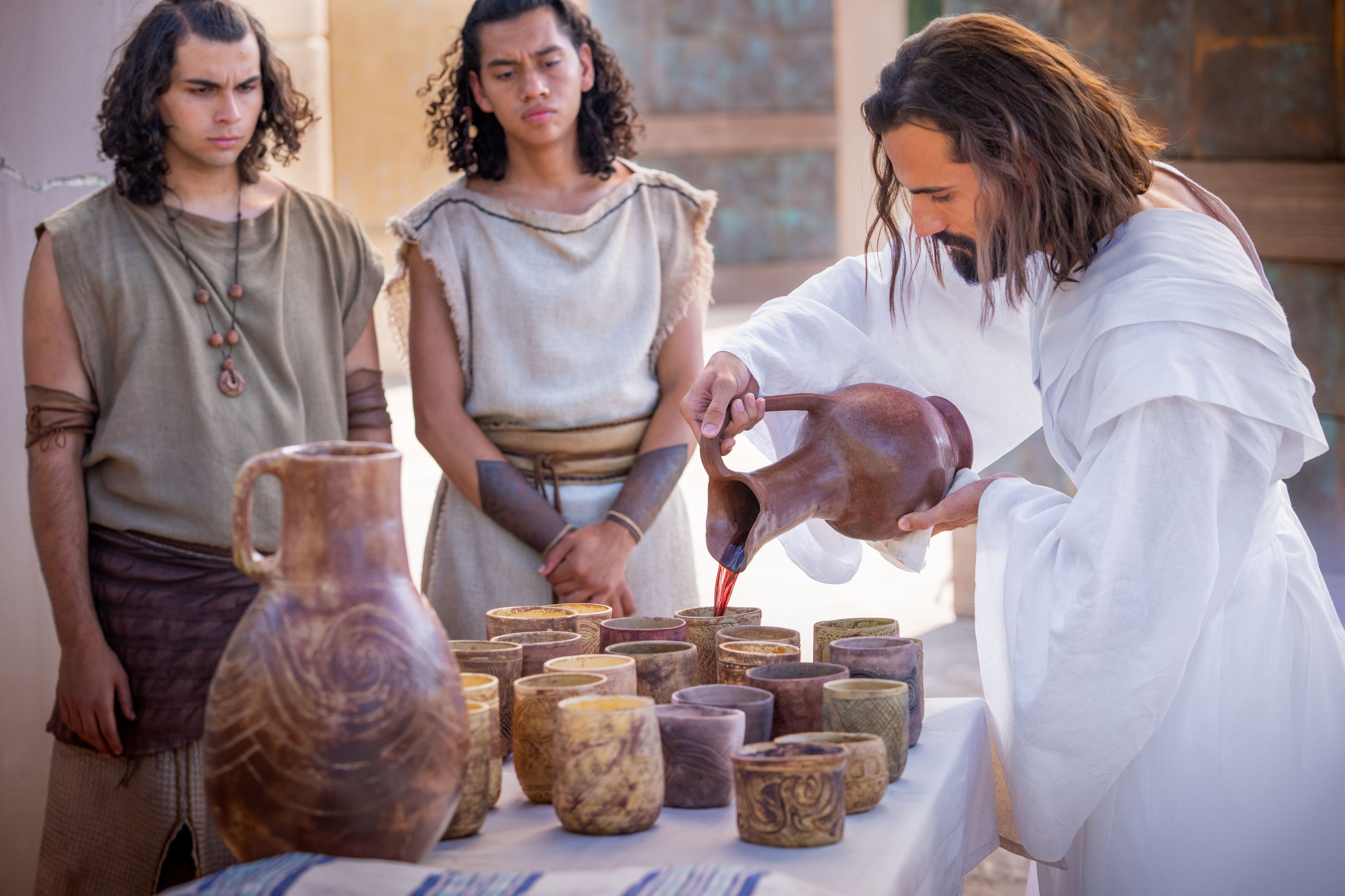 Jesus Christ hands the sacrament bread and wine to the Nephites.
