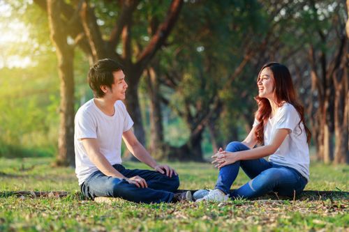 young man and woman talking in a park