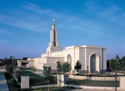 A view of the Lubbock Texas Temple from afar, with a black fence surrounding the grounds.