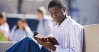 A black young adult man reading scriptures.