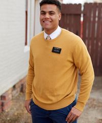 A missionary models appropriate dress and attire. He is wearing an approved sweater and pants.