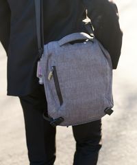 A missionary models appropriate dress and attire. He is wearing an approved suit and shoes and carrying an approved book bag.