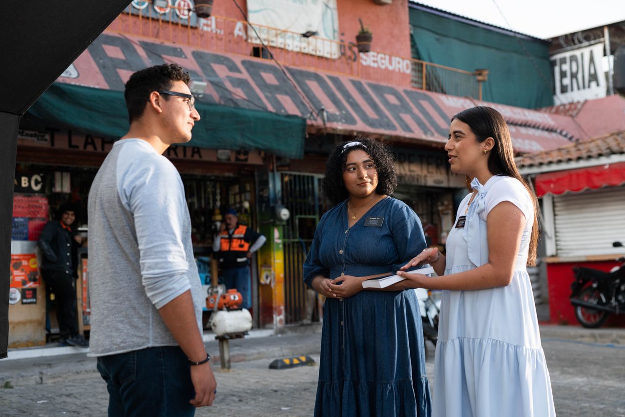Irmãs missionárias conversando com um homem do lado de fora de uma loja