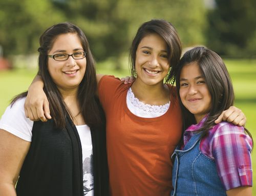 tre smilende unge kvinder