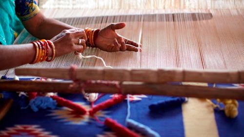 person weaving on a loom