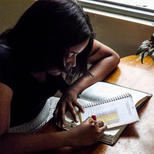 a young woman writing down goals