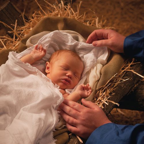 Jesus Kristus som ett spädbarn som ligger i en krubba