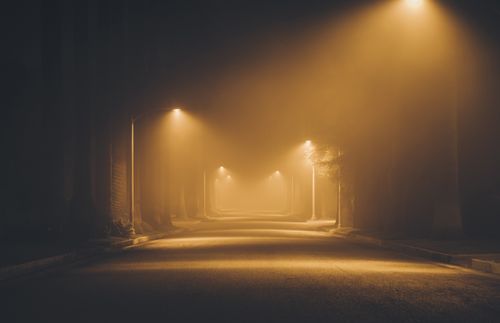 rua com neblina e postes acesos
