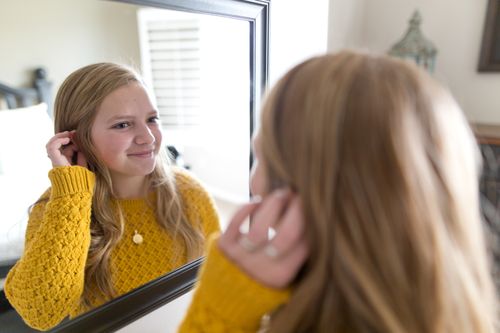 young woman looking in a mirror
