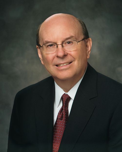Un ritratto dell’anziano Quentin L. Cook, che indossa un abito nero e una cravatta marrone e bianca, seduto davanti a uno sfondo grigio.