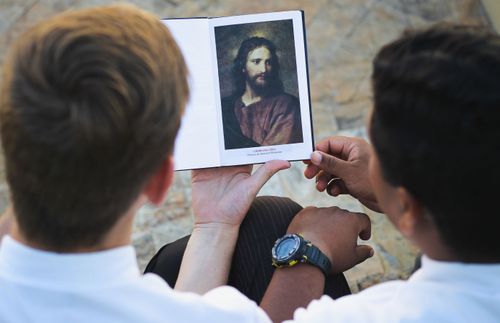 missionaries looking at a picture of Christ