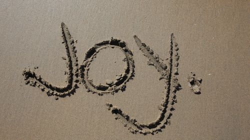 Joy written in the sand