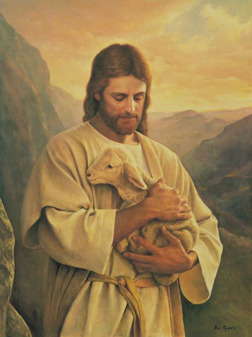 Christ in white robes, standing in a mountain scene, holding a small white lamb in both arms.