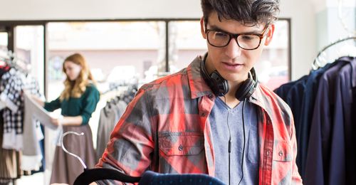young man looking at clothes