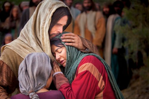 Mary and Martha embrace Jesus Christ as He stands and comforts them in His arms.