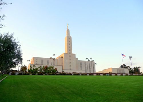 A view of the Los Angeles California Temple, with its bright green lawn in the foreground and a clear blue sky overhead.