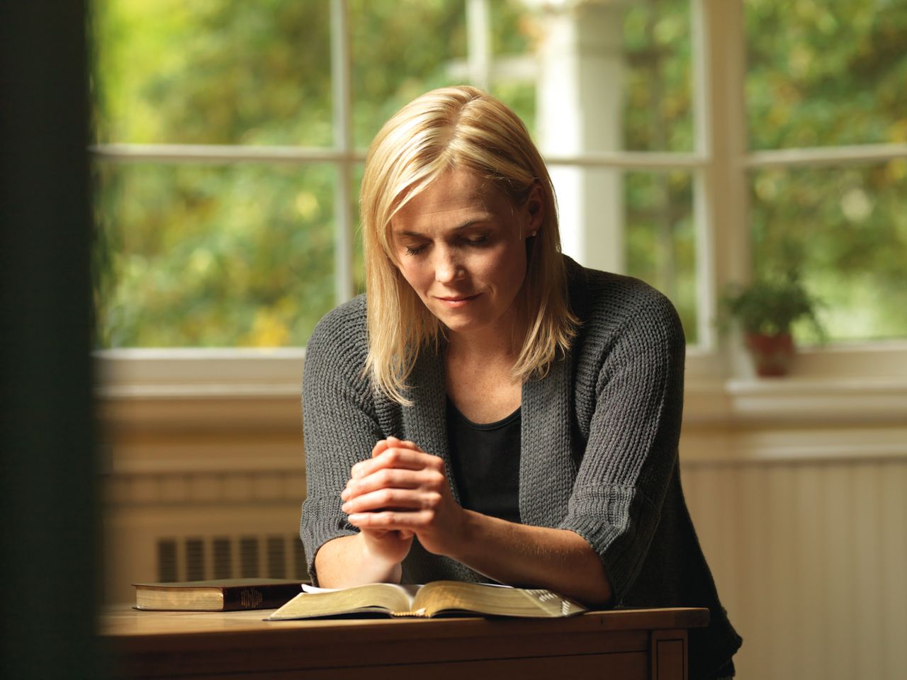 A woman praying before she reads her scriptures
