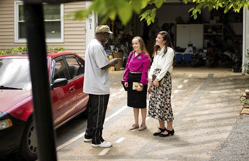 misioneras hablan con una persona en la calle.