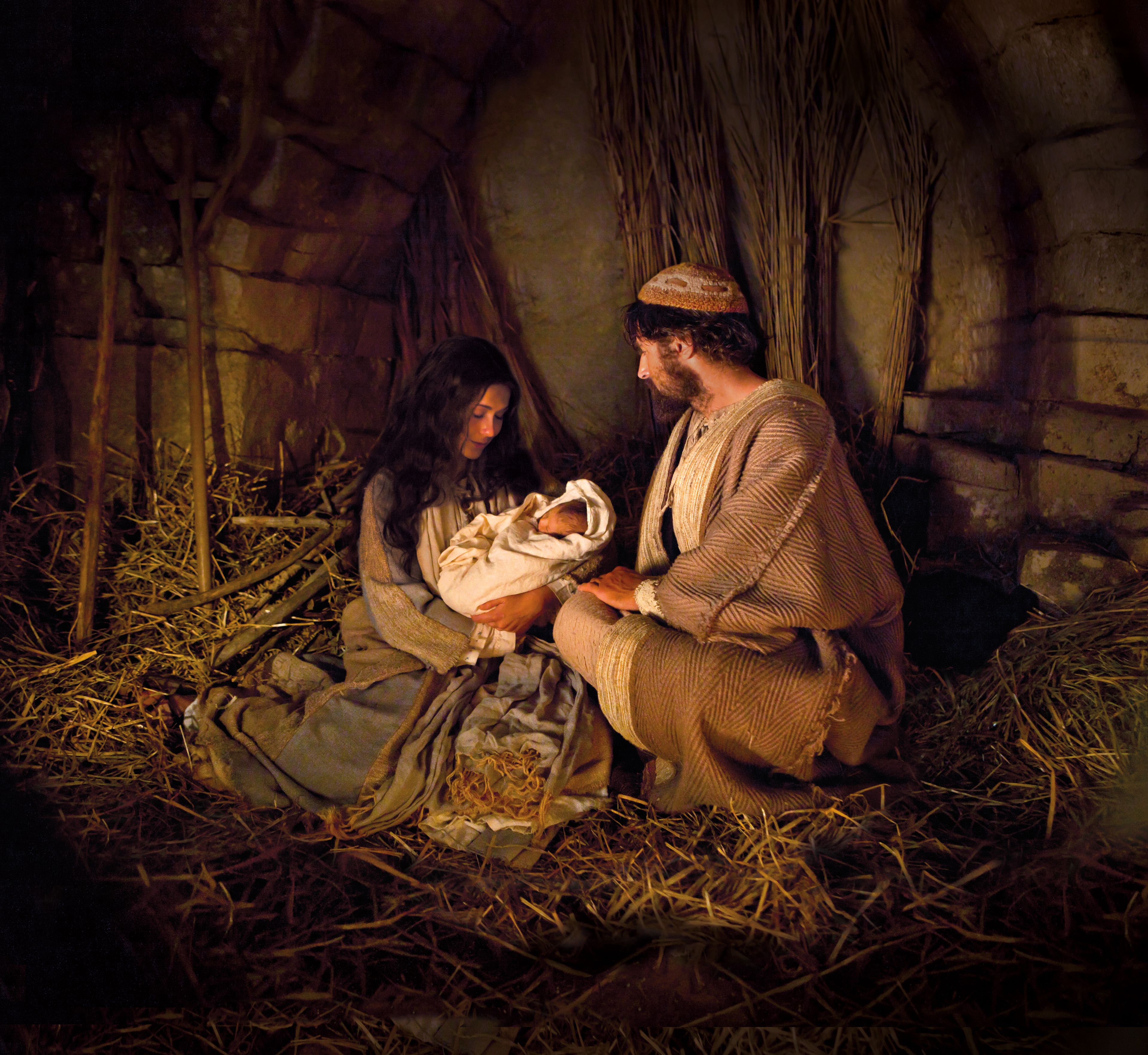 Joseph and Mary hold the baby Jesus on the night of His birth.