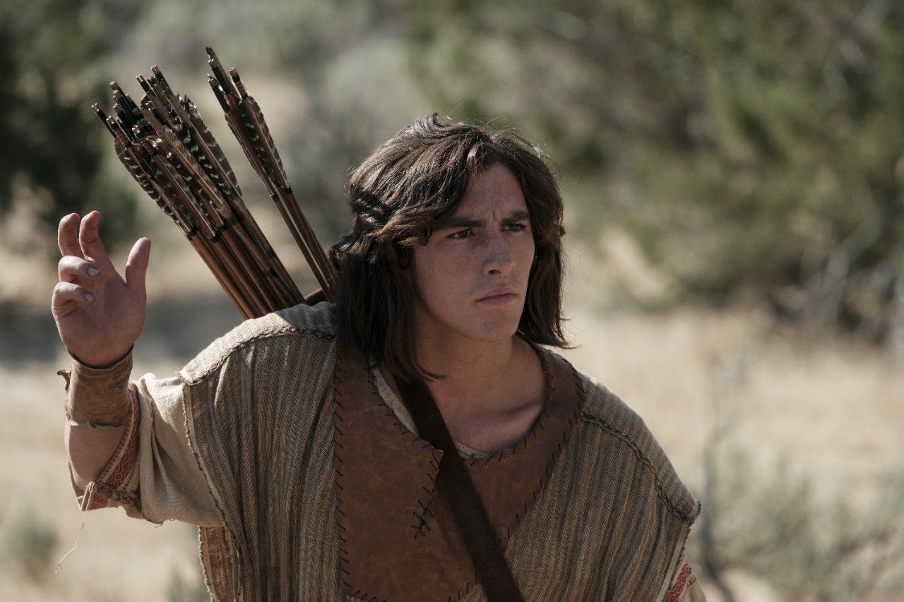 Nephi reaches for an arrow as he hunts in the wilderness.