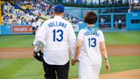 Elder and Sister Holland walk onto the pitcher's diamond at Dodger Stadium in Los Angeles, California, on June 28, 2013, prior to his ceremonial first pitch to begin the game.