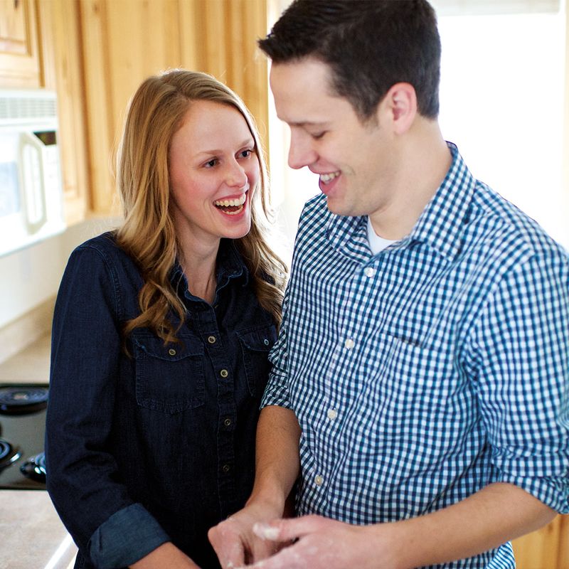 Um casal está em uma cozinha desfrutando a companhia um do outro