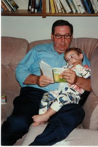 Elder Jeffrey R. Holland reading a book to his grandson.