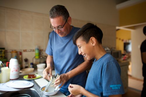 young man cooking with his dad