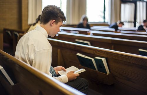 young man sitting in church alone