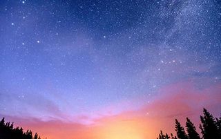 As estrelas começam a aparecer no céu à medida que o sol se põe mostrando a mão de Deus na natureza