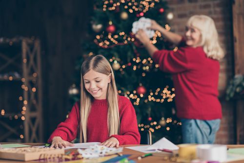 Jeune fille confectionnant des décorations de Noël avec sa grand-mère