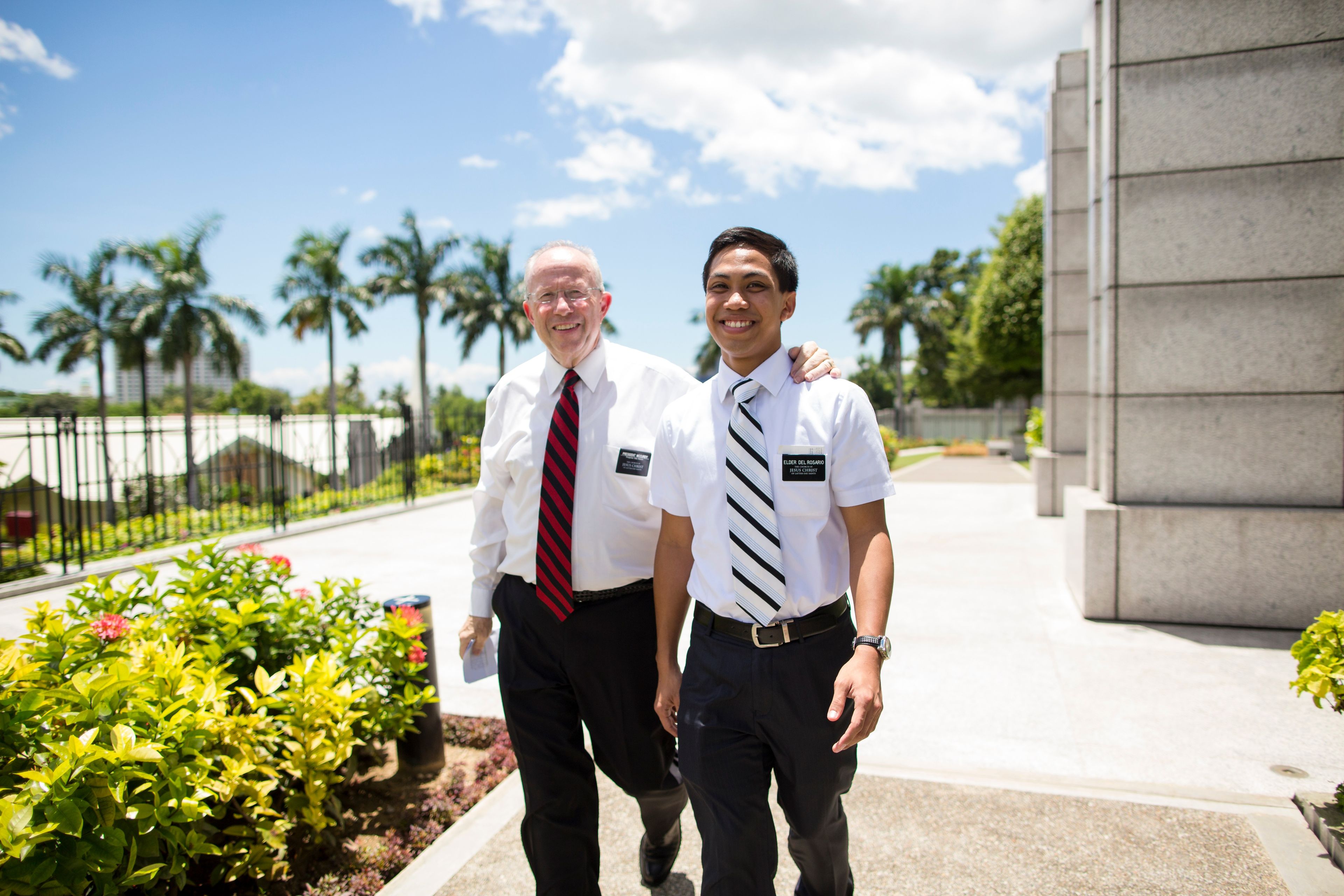 A senior elder missionary walking with a young elder missionary.