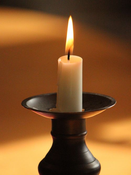 A lit candle on a candlestick.