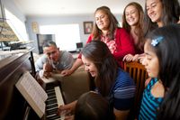 young woman playing piano for her family