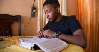 Ein Jugendlicher liest in den heiligen Schriften