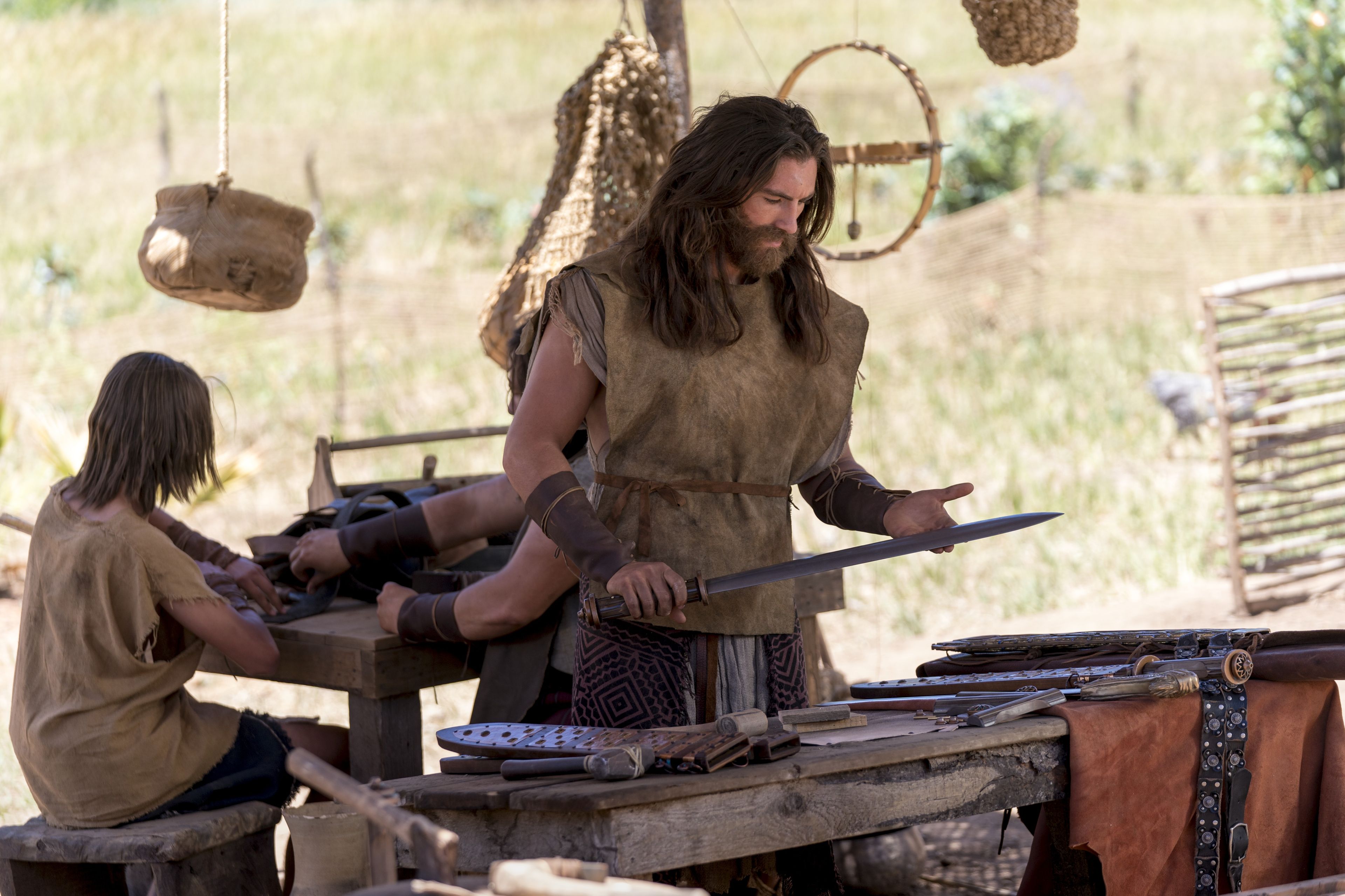 Nephi inspects a sword and other weapons.