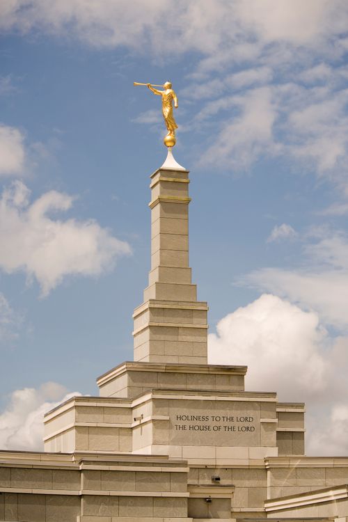 A close-up image of the spire and angel Moroni statue on top of the Aba Nigeria Temple on a sunny day.