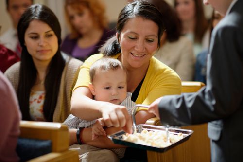 聖餐のトレイを前にする女性と子供